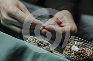 man rolling a joint, sitting at a table