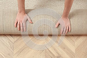 Man rolling out new carpet flooring indoors, top view. Space for text