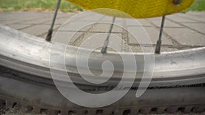 A man rolls a bicycle with a punctured tire on the wheel, flat tire