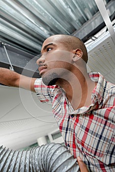 Man in roofspace with ventilation hose
