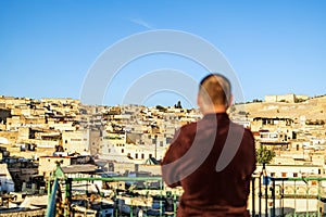 Man on the rooftop enjoying view of Fez old arabic medina, Morocco, Africa