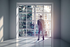 Man in room looking at city