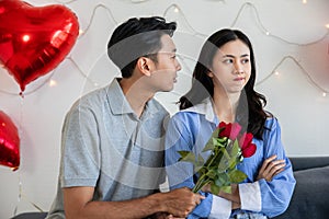 Man with rose  apologize to his girlfriend after they had an argument. Valentine day