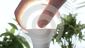 Man Rotates with His Hand a Led Bulb in Its Electrical Socket Opening the Light