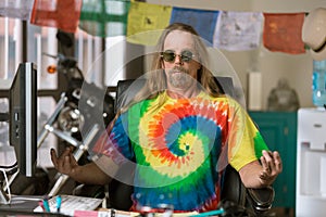 Man with Round Glasses Meditating in a Colorful Office