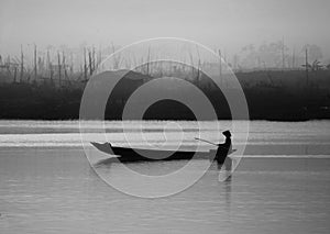 A man rowing boat in a misty lake