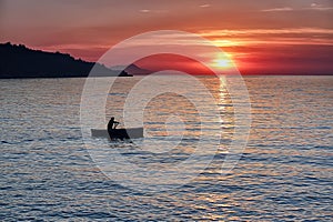 Man rowing a boat during sunset