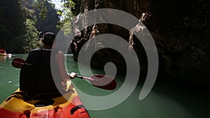 man rowing kayak across sea water