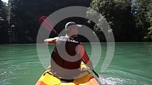 man rowing kayak on green sea water