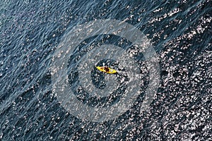 Man rows oar in kayak floats on sea