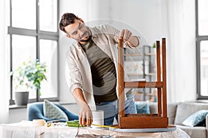 man with ruler measuring table for renovation