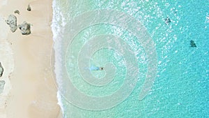 Man run on beach and jump to the ocean in sunny day. Aerial view. Top view