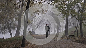 Man run in park in foggy autumn morning