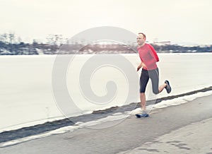 Man runing near winter lake photo