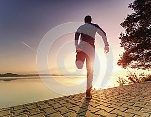 Man runner doing stretching exercise, prepare body for workout