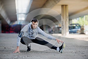 Man runner stretching before training outdoors