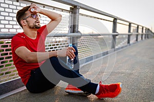 Man runner taking a break during training outdoors. Jogger resting after running.