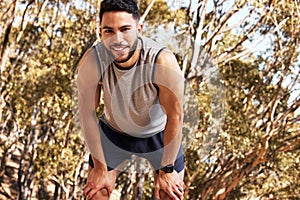 Man, runner and tired with smile for fitness in outdoors for wellness with exhaustion for exercise with fatigue in