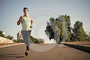 Man running on asphalt road on sunny summer day