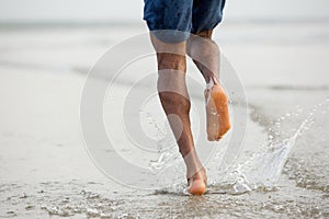 Man running barefoot in water