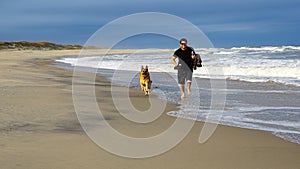 Man Running on Beach with Dog