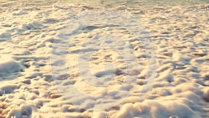 Man is running on the beach. Sea waves washing his legs.