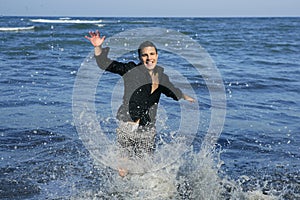 Man running happy on the blue summer beach