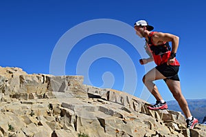 Hombre correr sobre el alto montana acera 