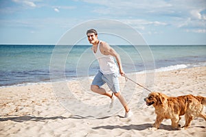 Man running with his dog on the beach