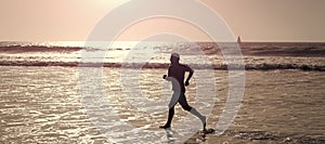 Man running and jumping, banner with copy space. athletic man runner silhouette run on summer beach with sea water and