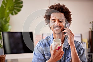 Man Running Online Business Making Boutique Candles At Home Talking On Mobile Phone