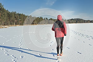 Man running outdoors on snow covering in winter nature