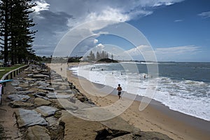Man running in a sandy beach in Moffat Beach, Sunshine Coast, Queensland, Australia