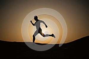 Man running silhouette at sunset, young caucasian run in mountain