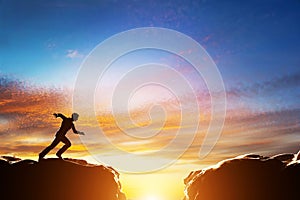 Man running to jump over precipice between two mountains photo