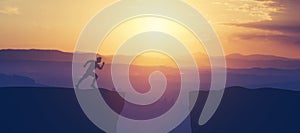 Man running towars cliff in the mountains.