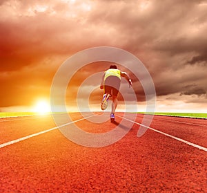 man running on the track with sunrise background