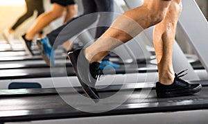 Man running on treadmill  machine at gym sports club. Fitness Healthy lifestye and workout at gym concept. Selective focus at mele photo