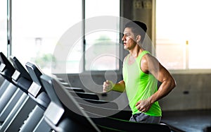 Man running on treadmill  machine at gym sports club. Fitness Healthy lifestye and workout at gym concept photo