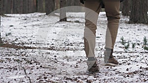 A man is running through the woods from the camera into the distance.