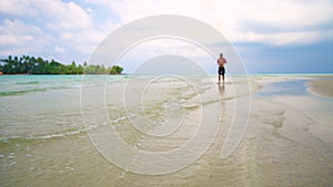 Man runs along tropical beach