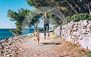 Man runs with dog near the sea