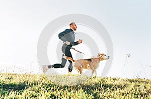 Man runs with his beagle dog. Morning Canicross exercise concept image