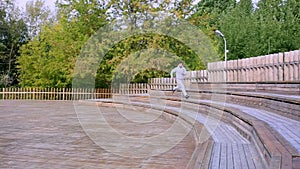 Man runs up a set of stairs in the park. Man jogging the stairs in park.