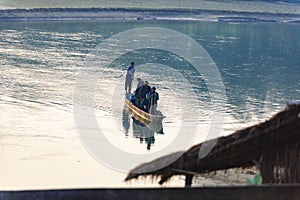 Man runs a wooden boat on the river, Nepal, Chitwan National Park,