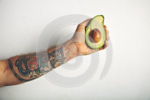 Man`s arm with half of avocado