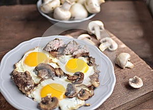 A man `s breakfast, a egg with mushrooms and meat for breakfast - this is a wonderful beginning of the day.