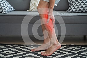 The man`s calf muscle cramped, massage of male leg at home