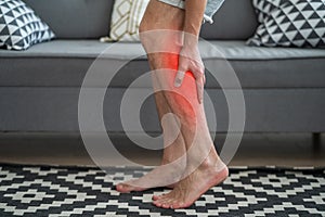 The man`s calf muscle cramped, massage of male leg at home photo