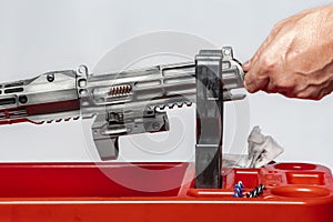 Man`s dirty hands cleaning the gun by metal brushes rifle parts details red plastic holder